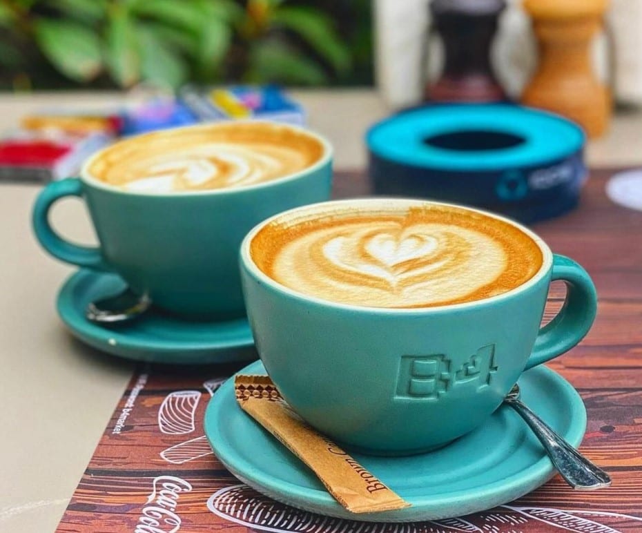 Two cappuccinos with latte art in branded B4 Market cups