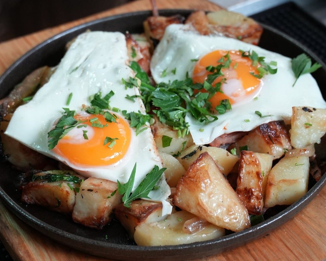 Shakshuka served in a cast iron pan with warm flatbread